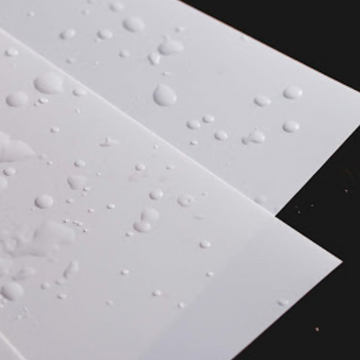 Waterproof testing with water droplets on matte white polypropylene synthetic paper surface