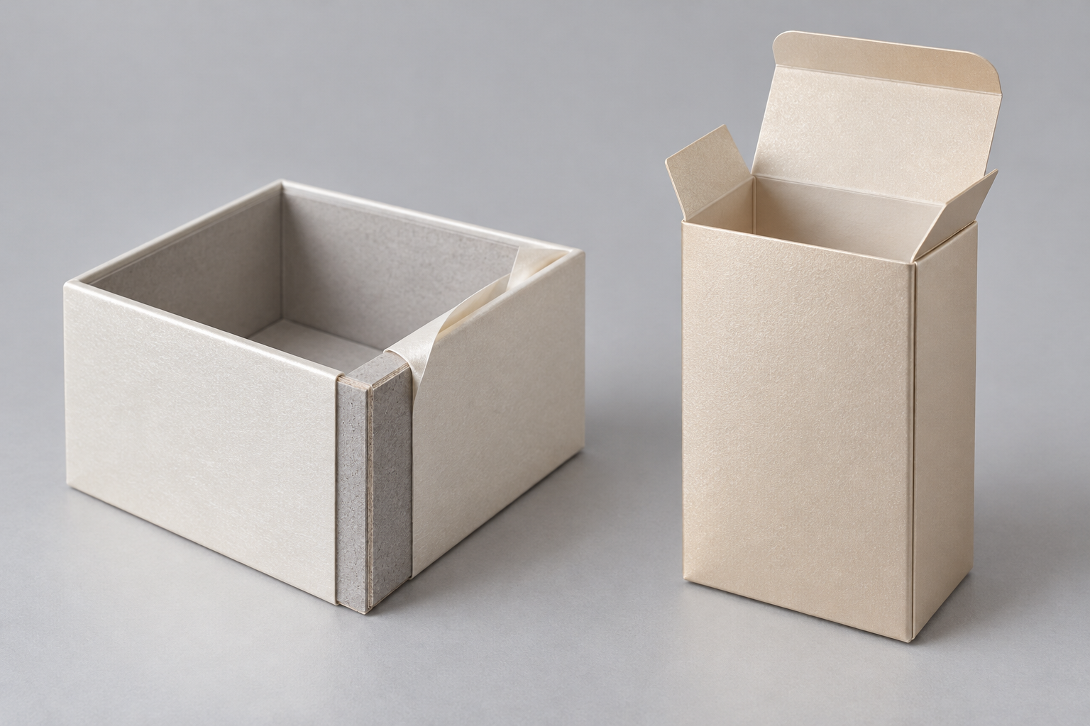 Rigid box corner with pearlescent wrapping paper beside a partially assembled folding carton